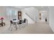 Open dining space with modern table and chairs, bright windows, and view of the staircase at 7255 Bold Rock Ave, Las Vegas, NV 89113