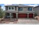 Stunning two-story home featuring a red three-car garage and stone accents at 7255 Bold Rock Ave, Las Vegas, NV 89113