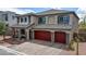 A charming home with a three-car garage, stone accents, and a welcoming entrance at 7255 Bold Rock Ave, Las Vegas, NV 89113