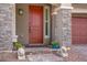 Charming front entrance with stone accents, lion statues, and a welcoming red door at 7255 Bold Rock Ave, Las Vegas, NV 89113