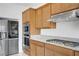Kitchen with stainless steel appliances, granite counters, wood cabinets at 7255 Bold Rock Ave, Las Vegas, NV 89113