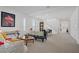 Bright, open-concept living room with neutral carpet, plantation shutters, and staircase at 7255 Bold Rock Ave, Las Vegas, NV 89113