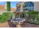 Detailed view of a sculptural multi-tiered fountain surrounded by lush greenery and manicured landscaping at 7333 Painted Shadows Way, Las Vegas, NV 89149
