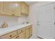 Laundry room features cabinets, tile countertops, a sink, and white door offering convenience and functionality at 7333 Painted Shadows Way, Las Vegas, NV 89149