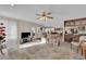 Spacious living room with tile flooring, adjacent to dining area and kitchen with bar seating at 7333 Painted Shadows Way, Las Vegas, NV 89149