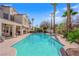 Backyard features a sparkling pool, covered patio with lounge seating, built in BBQ, and lush landscaping at 7333 Painted Shadows Way, Las Vegas, NV 89149