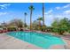 Backyard view of a private pool area with mature palm trees, lush landscaping, and lounge area at 7333 Painted Shadows Way, Las Vegas, NV 89149