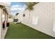 Fully landscaped backyard with artificial grass, outdoor seating, and block wall at 7925 Limbwood Ct, Las Vegas, NV 89131