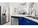 Open kitchen with stainless steel appliances, white marble countertops, and blue cabinets at 7925 Limbwood Ct, Las Vegas, NV 89131
