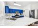 Bright kitchen with blue cabinets, marble countertops, and stainless steel appliances, offering a modern cooking space at 7925 Limbwood Ct, Las Vegas, NV 89131