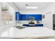 Modern kitchen with marble countertops, stainless steel appliances, and bright blue cabinets, complemented by natural light at 7925 Limbwood Ct, Las Vegas, NV 89131