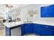 Open kitchen with an eat-in bar, white marble countertops, and bright blue cabinets at 7925 Limbwood Ct, Las Vegas, NV 89131