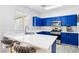 Stylish kitchen featuring blue cabinets, marble countertops, bar seating, and stainless steel appliances, with a modern flair at 7925 Limbwood Ct, Las Vegas, NV 89131