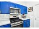 Bright kitchen featuring stainless steel appliances, blue cabinets, and white marble countertops at 7925 Limbwood Ct, Las Vegas, NV 89131