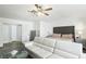 Bright main bedroom featuring a ceiling fan, sleek furniture, and a comfortable couch at 7925 Limbwood Ct, Las Vegas, NV 89131
