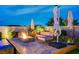 Cozy backyard featuring a fire pit with seating, umbrellas, and lush landscaping, perfect for outdoor gatherings at 8298 W Agate Ave, Las Vegas, NV 89113