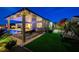 Beautiful backyard with outdoor kitchen, pool access, patio, swing, and manicured landscaping perfect for relaxing at 8298 W Agate Ave, Las Vegas, NV 89113