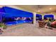 Lush backyard with a sparkling pool, covered patio, comfortable seating, and a serene atmosphere at 8298 W Agate Ave, Las Vegas, NV 89113