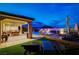 Picturesque backyard features a sparkling pool, covered patio with seating, and lush landscaping at 8298 W Agate Ave, Las Vegas, NV 89113