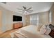 Bright bedroom features wood floors, TV, ceiling fan, and plantation shutters at 8298 W Agate Ave, Las Vegas, NV 89113
