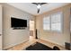 Bedroom with mounted TV, and view into the bathroom, features light hardwood flooring at 8298 W Agate Ave, Las Vegas, NV 89113