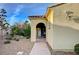 Inviting home entrance featuring an arched doorway, stone walkway, desert landscaping, and a warm, welcoming ambiance at 8298 W Agate Ave, Las Vegas, NV 89113