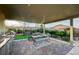 Outdoor kitchen with a built-in stainless steel grill and covered patio seating area at 8298 W Agate Ave, Las Vegas, NV 89113