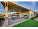 Outdoor kitchen with stainless steel appliances and covered dining area with artificial grass at 8298 W Agate Ave, Las Vegas, NV 89113