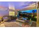 Charming outdoor kitchen featuring stainless steel appliances, dining table, and comfortable seating in a covered patio at 8298 W Agate Ave, Las Vegas, NV 89113