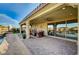 Stylish covered patio with comfortable seating, overlooking the pool and landscaped backyard at 8298 W Agate Ave, Las Vegas, NV 89113
