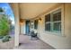 Cozy covered porch with brick flooring, comfortable seating, and stylish lighting, offering a relaxing outdoor space at 8298 W Agate Ave, Las Vegas, NV 89113
