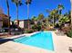 Community pool with blue water, lounge chairs, and well-maintained grounds surrounded by palm trees at 9000 S Las Vegas Blvd # 1187, Las Vegas, NV 89123