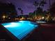 Community swimming pool with blue water illuminated at night, surrounded by palm trees and landscape at 9000 S Las Vegas Blvd # 1187, Las Vegas, NV 89123