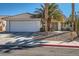 Charming single-story home with a two-car garage and desert landscaping including palm trees at 914 Calico Brook Dr, Henderson, NV 89002