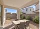 Relaxing backyard patio featuring a dining set and desert landscaping, perfect for enjoying outdoor meals at 9233 Far Side Ave, Las Vegas, NV 89143