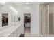 Bathroom featuring dual sinks, walk-in shower with glass door, and a walk-in closet with ample storage at 9233 Far Side Ave, Las Vegas, NV 89143