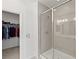 Modern bathroom with a glass-enclosed shower and a glimpse into the walk-in closet with visible clothing at 9233 Far Side Ave, Las Vegas, NV 89143