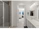 Bathroom featuring a glass shower, double vanity with white countertops and a glimpse into the bedroom at 9233 Far Side Ave, Las Vegas, NV 89143