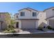 Inviting two-story home featuring a well-kept front yard, brick driveway, and attached two-car garage at 9233 Far Side Ave, Las Vegas, NV 89143