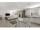 Open-concept living and kitchen area with large windows and sliding doors to the rear patio at 9233 Far Side Ave, Las Vegas, NV 89143
