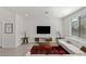 Bright living room featuring a comfortable white sofa, modern console, and large-screen TV at 9233 Far Side Ave, Las Vegas, NV 89143