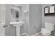 A well-lit half bathroom featuring a pedestal sink, toilet, and storage at 965 Nevada State Dr # 36102, Henderson, NV 89002