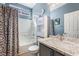 This renovated bathroom features a shower-tub combo, and a grey vanity with marble countertop at 10435 Meadow Village St, Las Vegas, NV 89183