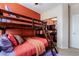 This cozy bedroom features a wood bunkbed, ceiling fan and natural light from the sliding mirrored closet doors at 10435 Meadow Village St, Las Vegas, NV 89183
