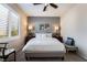Bright bedroom features a queen-size bed, neutral decor, ceiling fan, and a window letting in natural light at 10435 Meadow Village St, Las Vegas, NV 89183