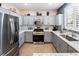Modern kitchen features stainless steel appliances, gray cabinets, and granite countertops at 10435 Meadow Village St, Las Vegas, NV 89183