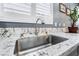 Close-up of the kitchen sink featuring stainless steel hardware and a marble countertop at 10435 Meadow Village St, Las Vegas, NV 89183
