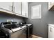 Efficient laundry room features modern appliances and ample cabinet space, designed for convenience and organization at 10435 Meadow Village St, Las Vegas, NV 89183