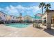 Community pool area with comfortable seating, lush palm trees and inviting umbrellas at 10435 Meadow Village St, Las Vegas, NV 89183