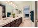 Dual sink bathroom featuring a large vanity mirror with modern lighting at 138 Wentworth Dr, Henderson, NV 89074